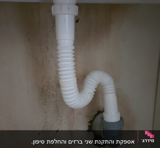 צינור ניקוז לבן מתחת לכיור עם חיבור אפור